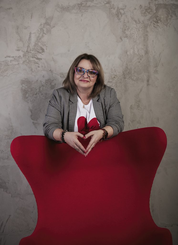 sesja wizerunkowa kobieta stoi przy fotelu